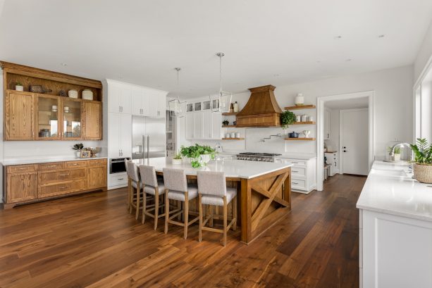 hickory cabinets and dark wood floor in a white-dominated kitchen