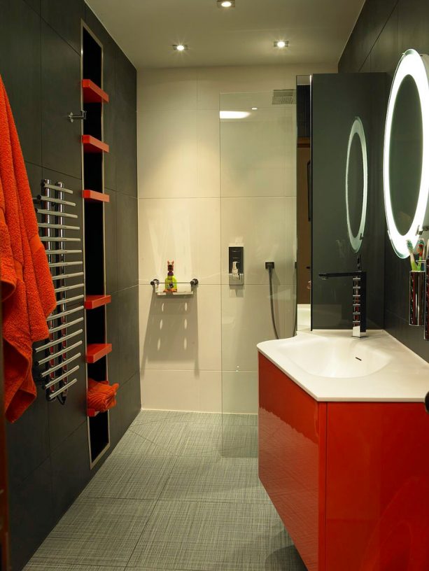 a contemporary bathroom with red and black color theme