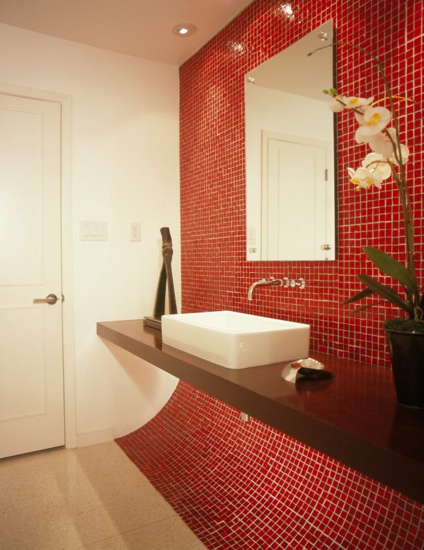 a contemporary bathroom with unique red mosaic glass accent wall and floating black vanity