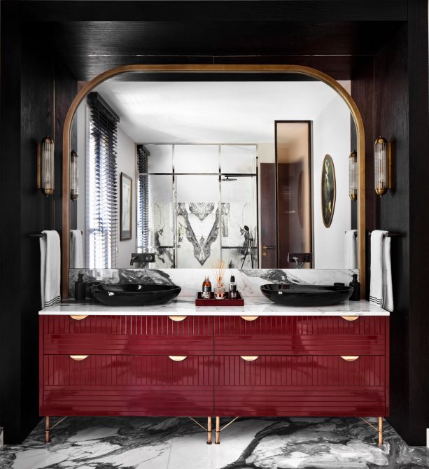 a luxurious red and gold vanity placed in front of a black wall surround