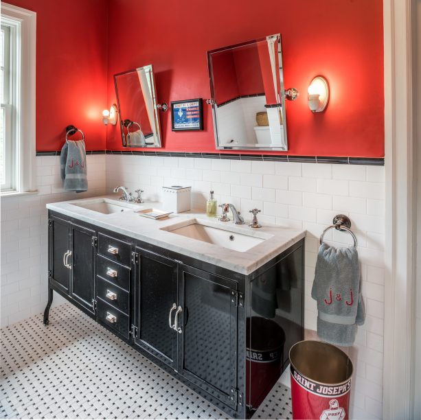 an eclectic bathroom with glossy black double-sink vanity and red walls