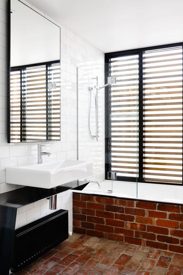 the combination of red brick material and black color in a contemporary bathroom