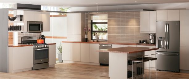 a modern kitchen with slate appliances, white cabinets, and wooden countertops