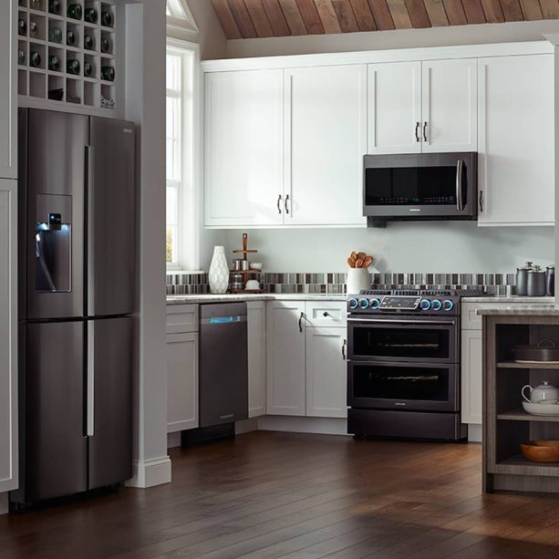 a white contemporary kitchen with complete slate appliances and white cabinets