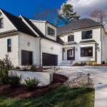 a white transitional house with black roof