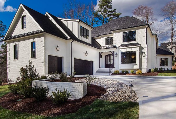 a white transitional house with black roof