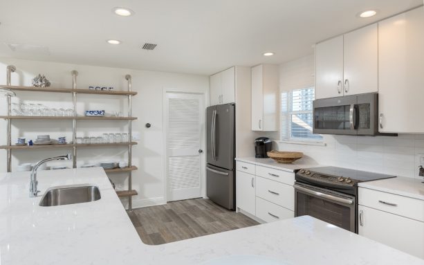 slate appliances and white cabinets in a white beach-style kitchen