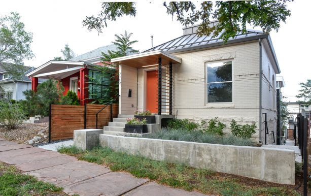 a tan brick house with metal roof