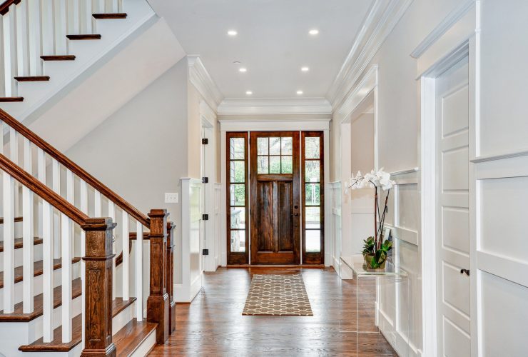 a transitional front door with glossy appearance and white trim
