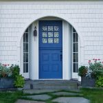 a unique entry design with navy Dutch-style front door