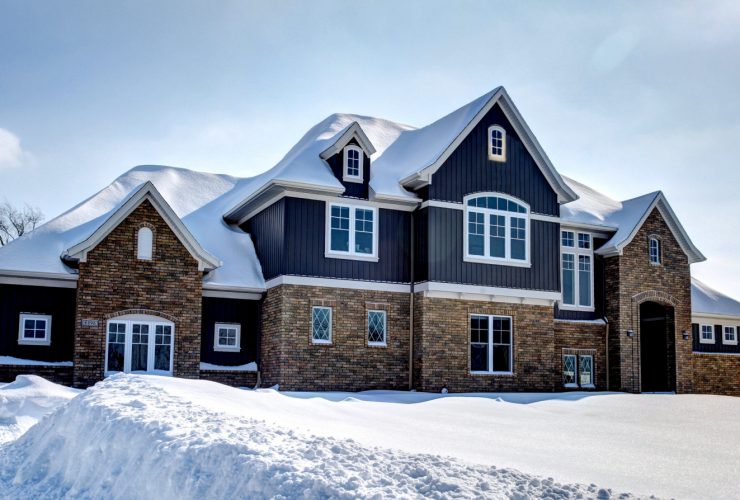 a craftsman house with half mixed brick and half navy blue siding