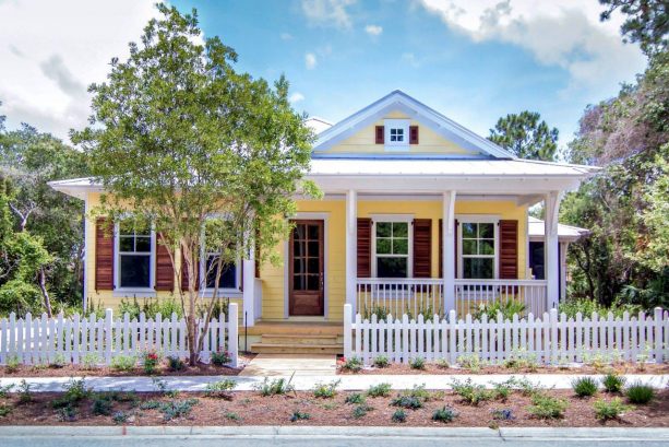 a beach-style exterior with yellow, white, and stained wood tones
