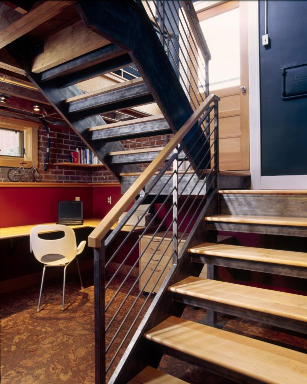 a contemporary no-riser basement staircase with an office under it