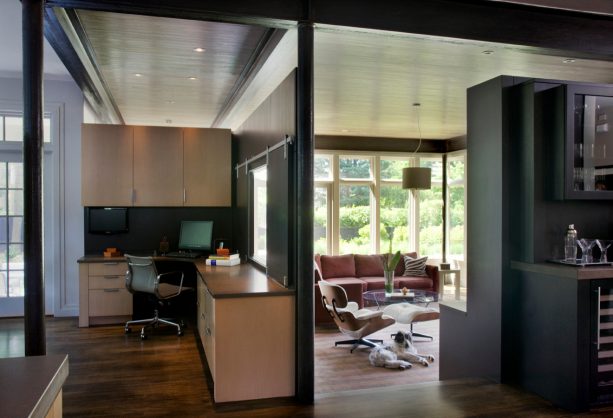 a glassless window with black sliding closures as a part of a partition in a contemporary interior