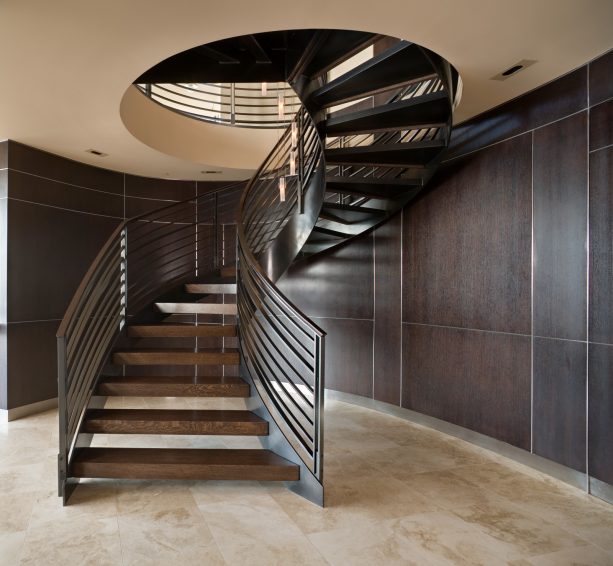 a large and trendy helical open staircase leads to basement