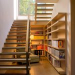 a reading area under an open staircase that leads to a basement