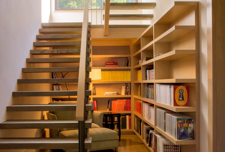 a reading area under an open staircase that leads to a basement