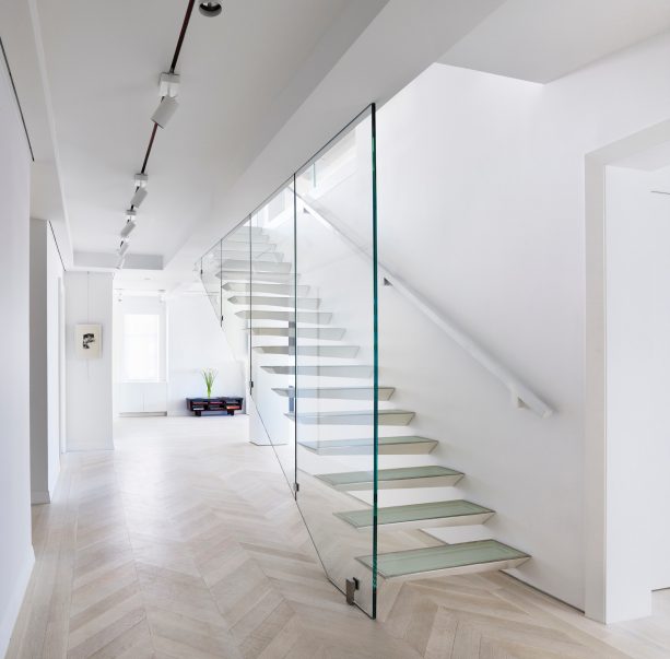 a unique glass open staircase in a contemporary basement design