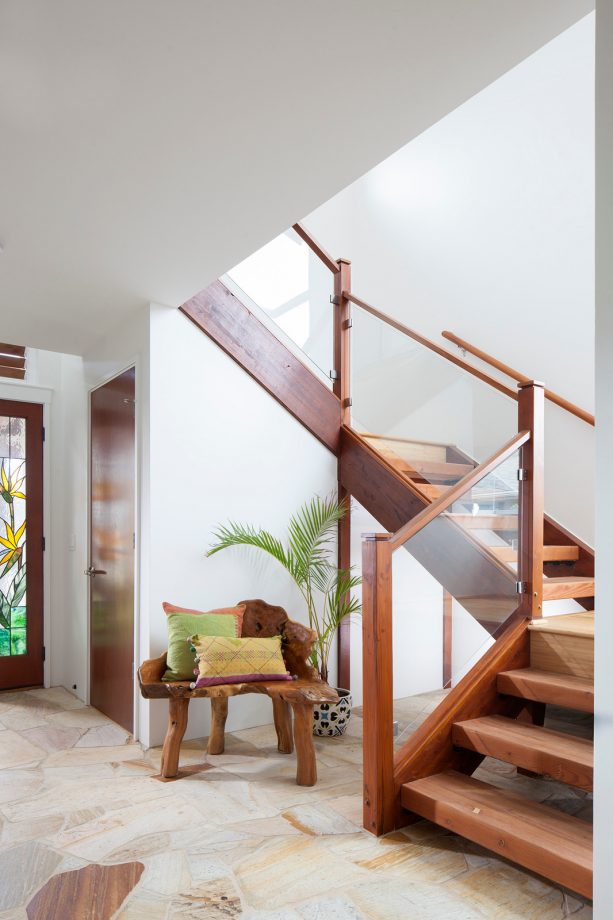 a wood-framed glass railing in a contemporary basement open staircase