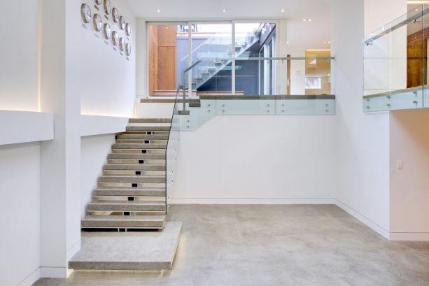 simple yet stunning concrete open staircase directing to the basement area