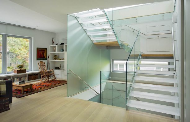 the combination of resin treads and glass railing in an open staircase
