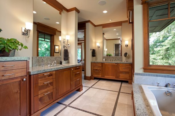 a craftsman bathroom with coordinating vanities and crown molding