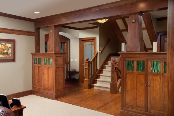 a craftsman entry with crown molding, tapered posts, and exposed beam