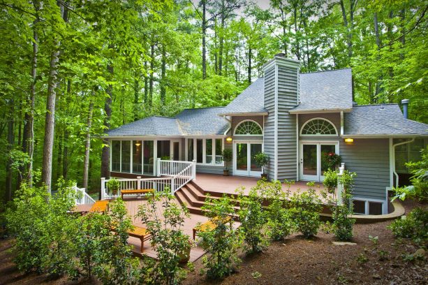 a traditional house with grey siding and brown deck