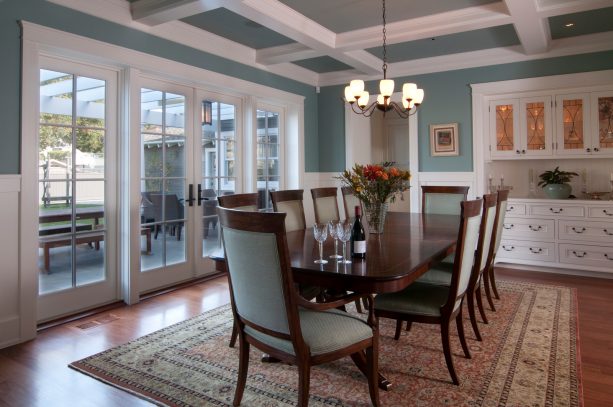 craftsman dining room design with exposed beams connected to the crown molding
