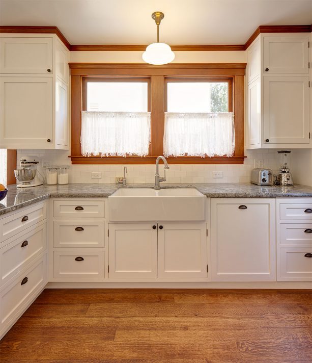 the beautiful combination of stained-wood crown molding and white cabinets in a craftsman kitchen interior