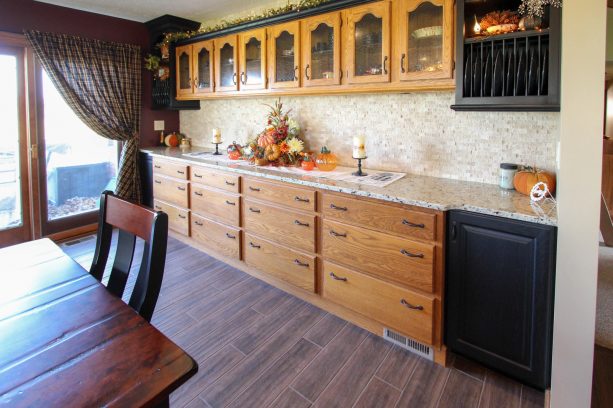 the updated cabinets get black accents, new countertops, and new backsplash