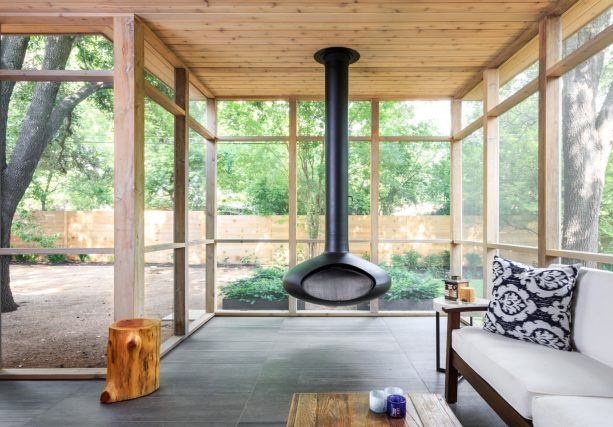 a black hanging fireplace in a modern screened porch