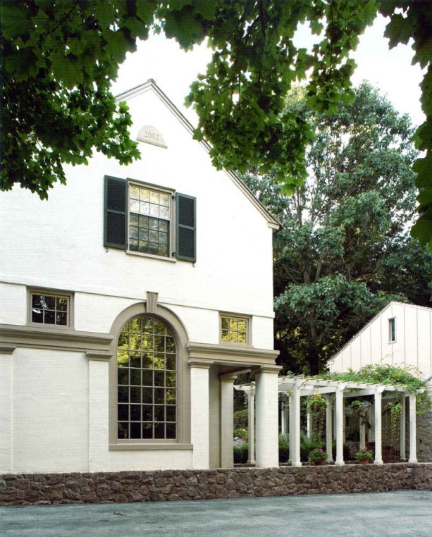 a cream-white house with greige exterior trim around the windows