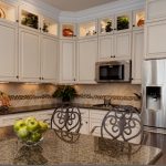 a traditional kitchen with the combo of glazed white cabinets and tropic brown granite