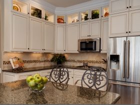 a traditional kitchen with the combo of glazed white cabinets and tropic brown granite