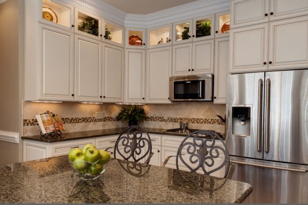 a traditional kitchen with the combo of glazed white cabinets and tropic brown granite