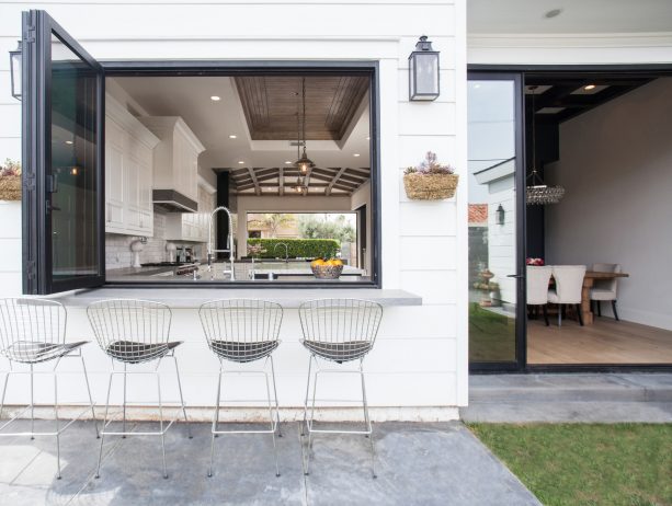 a black bi-fold pass through window looks attractively simple being paired with the white wall siding