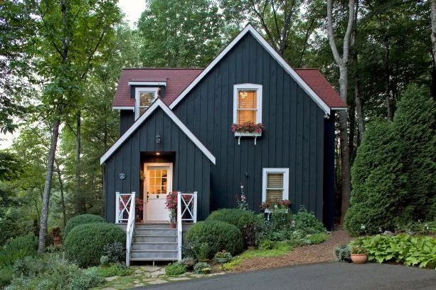 a fabulous traditional mountain home with black -painted vertical siding
