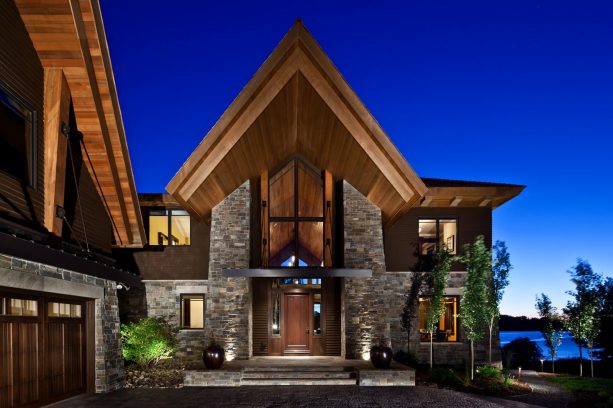 a modern-style mountain house with the mixture of brown-painted siding and stone material