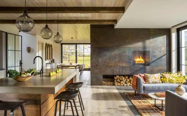 a very stunning metal fireplace in an industrial x farmhouse open-style living interior