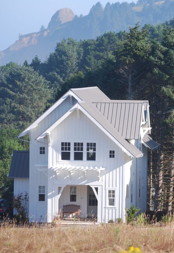 a white-painted farmhouse-style mountain home with grey roof