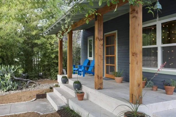 mountain house with dark blue-painted siding and clear-stained douglas fir columns