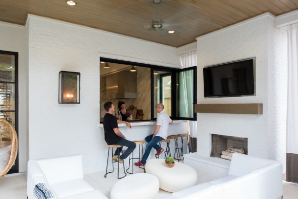 trendy black pass through window between a kitchen and a semi-outdoor living area