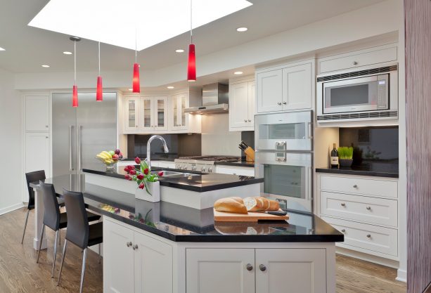 a black and white contemporary kitchen with elegant red pendant lights above the island