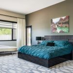 a black modern bed decorated with teal bedding set