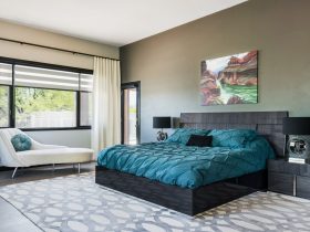a black modern bed decorated with teal bedding set