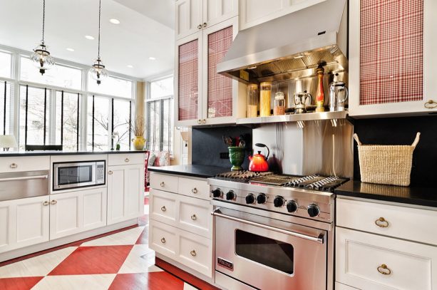 a hardwood flooring is painted in red and white in a traditional black and white kitchen interior