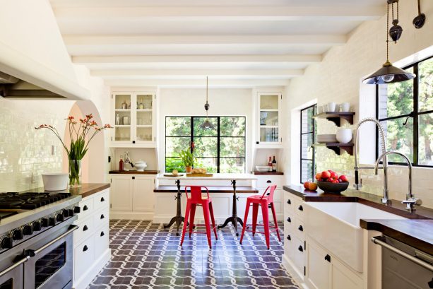 a mediteranean black and white kitchen with breakfast area with red stools