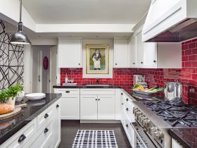 a red subway tile backsplash looks stunning in a black and white transitional kitchen interior