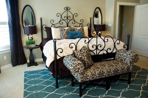 a teal area rug placed under an elegant contemporary metal bed